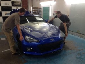 blue car with protection film being installed